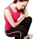 Une femme est déprimée quand elle voit son poids sur la balance