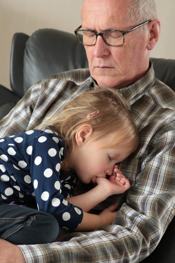 un grand-père et sa petite fille font la sieste