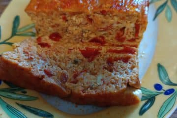 Un plat dans lequel est posé un pain de poivron et une tranche découpée de ce pain