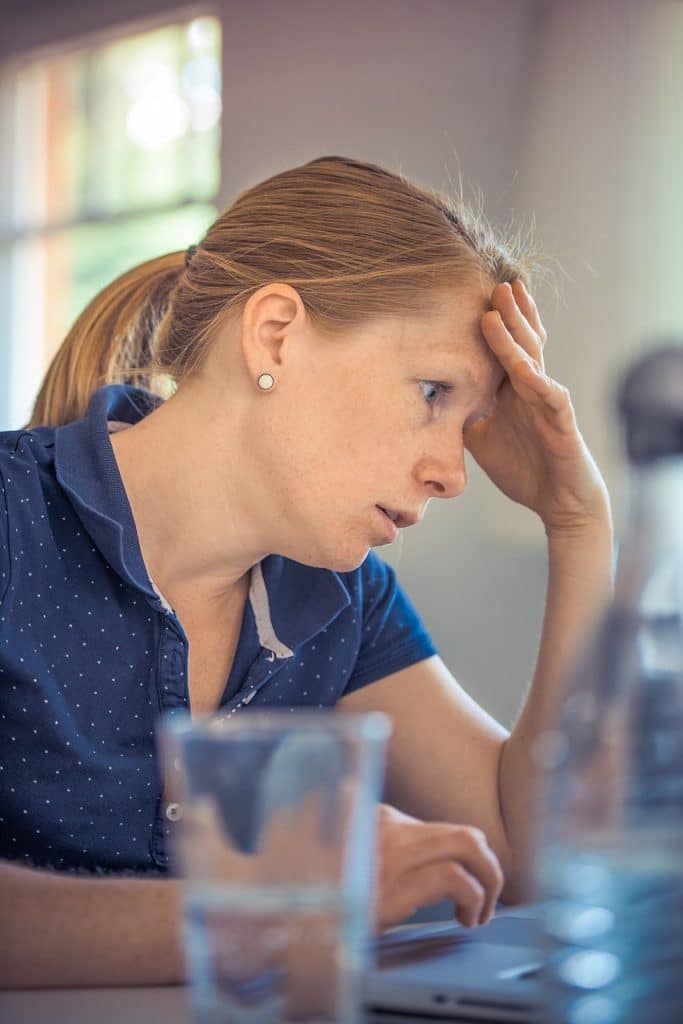 Une femme devant son ordinateur semble stressée