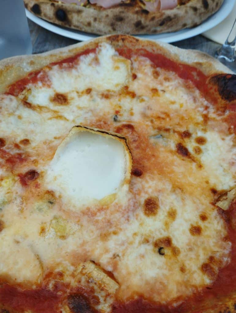 Une photo de pizza maison, avec du fromage de chèvre